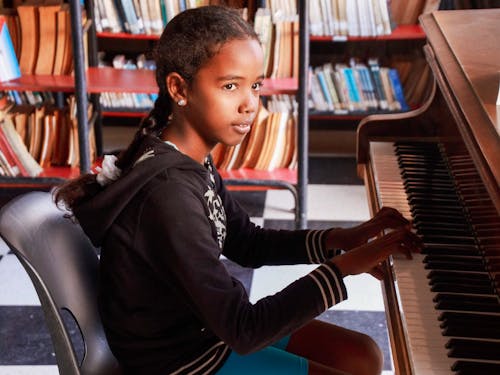 Free Young Girl Playing a Piano Stock Photo