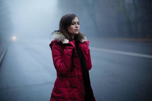 Free Woman in Red Jacket Standing on Roadside Stock Photo