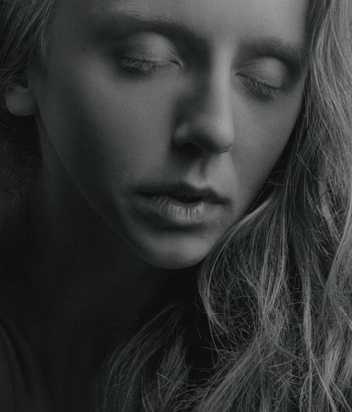 Free Close-up monochrome portrait of a woman with eyes closed, expressing serenity and introspection. Stock Photo