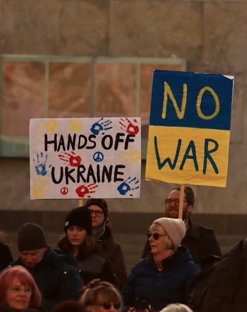 People Holding White and Blue Signage