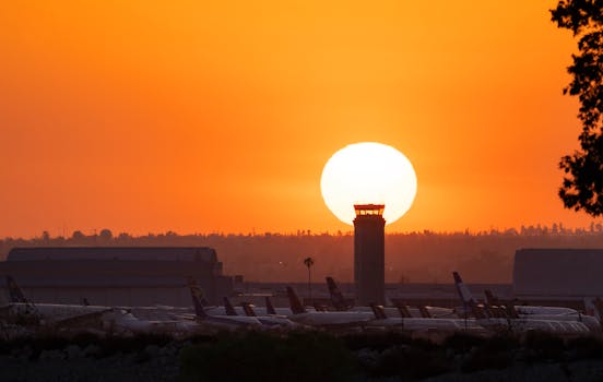 Airplanes at San Bernardino Airport silhouetted against a vibrant sunset.