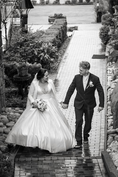Bride and Groom in Walking on a Paved Pathway · Free Stock Photo