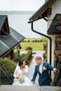 A Bride and a Groom Holding Hands Near a Hand Rail