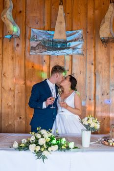 Bride and groom share a romantic kiss during an indoor wedding ceremony.
