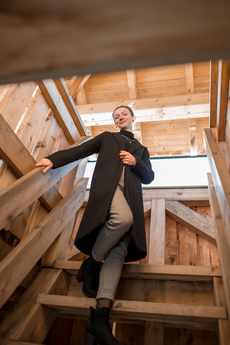 Woman In Black Coat Coming Down The Stairs