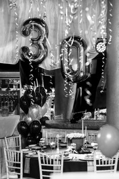 Stylish black and white 30th birthday party setup with balloons and decorations.