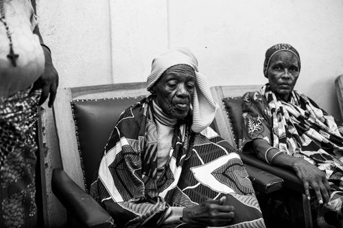 Free Black and white photo of two elderly women sitting in traditional African clothing indoors. Stock Photo