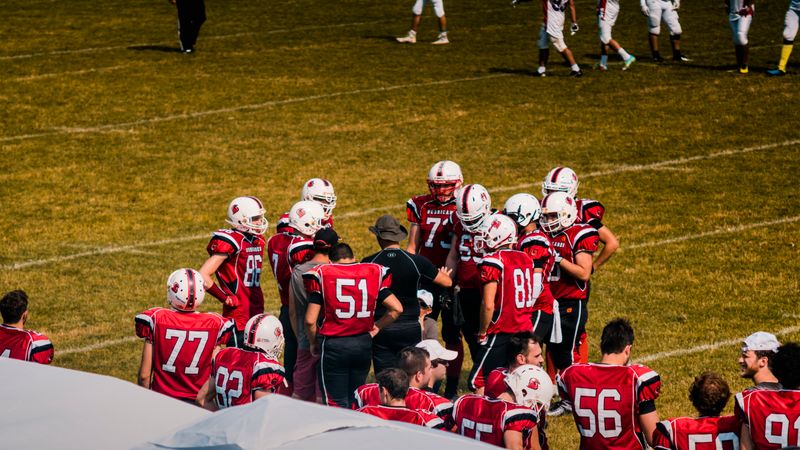 American football team huddling on field for strategy meeting during a game.