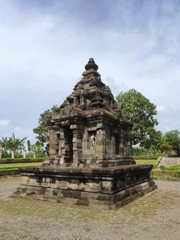 Explore this historic temple in Yogyakarta, showcasing ancient architecture amidst lush greenery. - Fotografer Sidoarjo