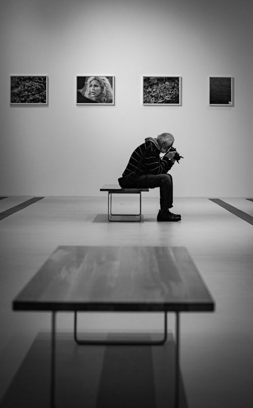 Man Sitting on Chair in a Gallery