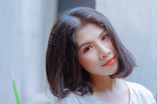 Charming young woman with makeup posing outdoors, showcasing beauty and style.