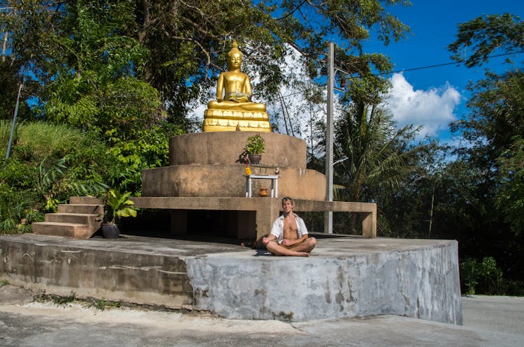 A Man Sitting Near The Buddha