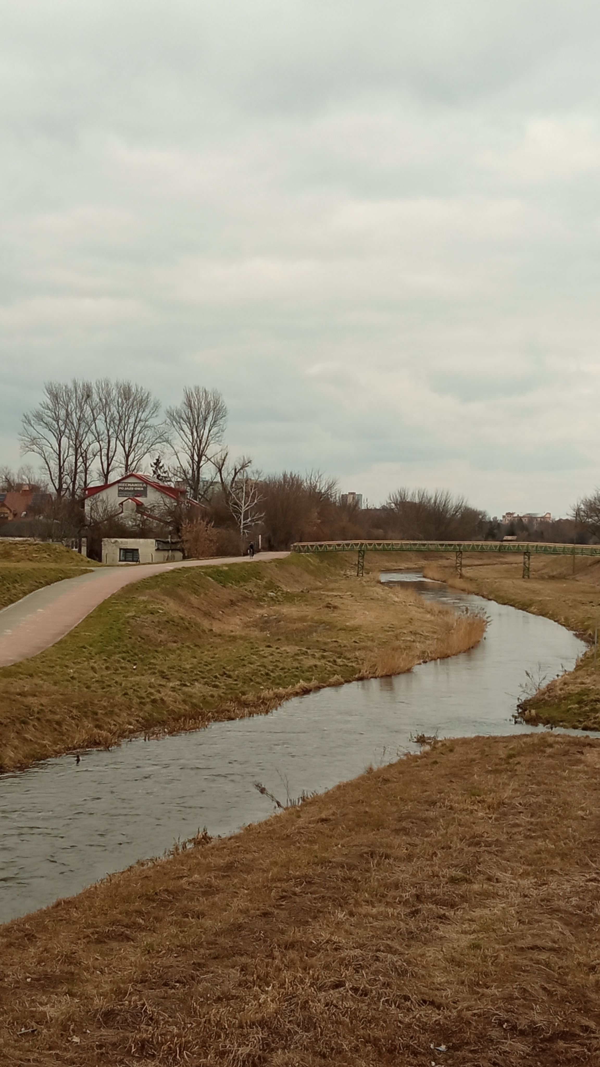 A tranquil view of a small river winding through the countryside near Lublin, Poland.