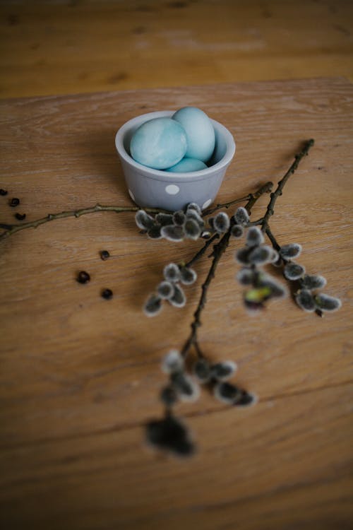 Blue Eggs on Ceramic Bowl on Brown Wooden Surface