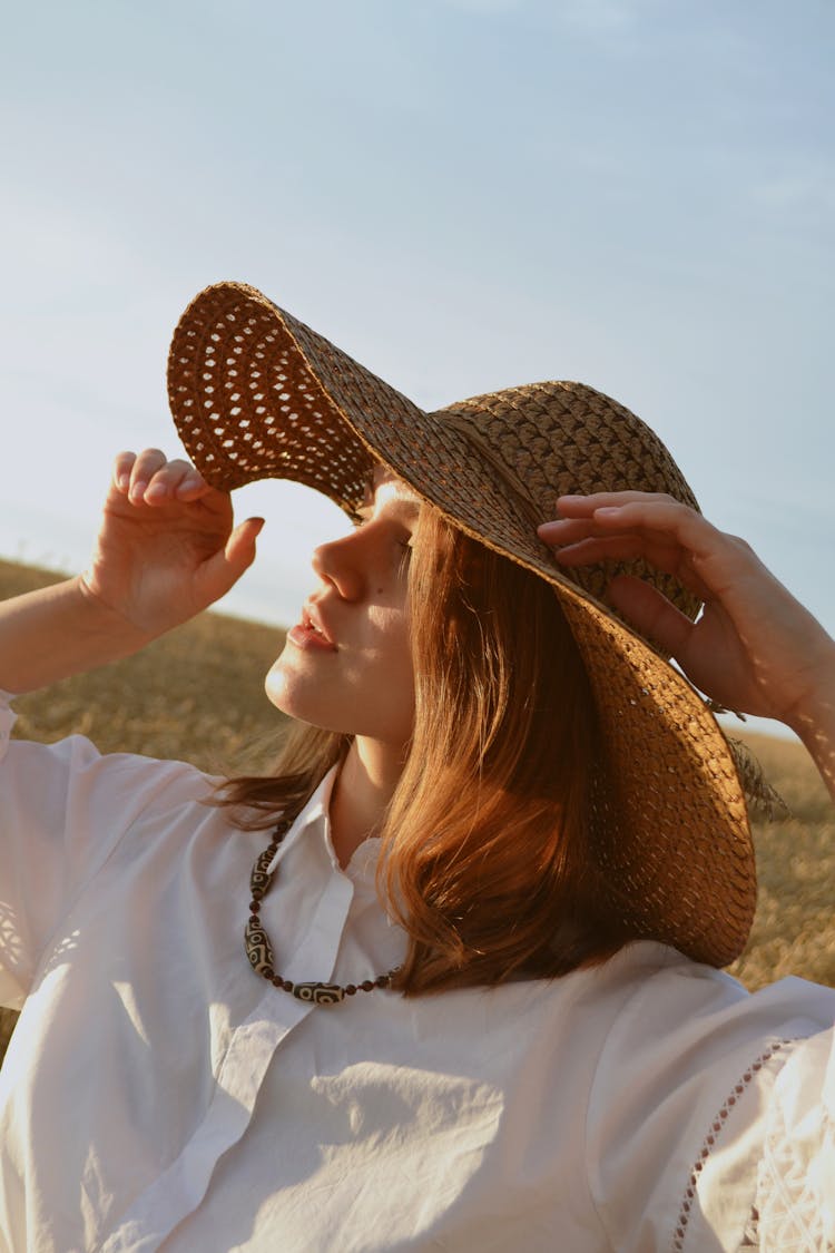 Redhead Woman In Straw Hat Looking To Sun