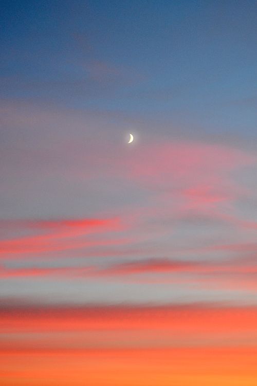 Free A serene sky at sunset with vibrant colors and a crescent moon. Stock Photo