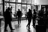 黑白剪影的人物走过繁忙的室内大厅