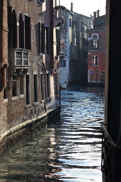 Free Charming Venetian canal lined with historic townhouses in soft light, reflecting the iconic architecture. Stock Photo