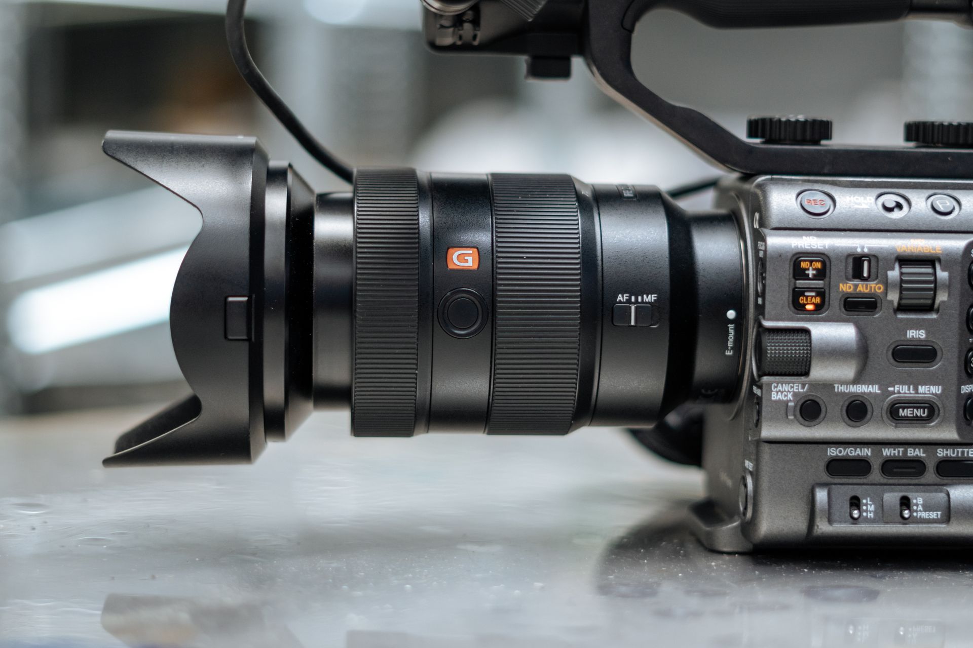 Close-up of high-end video camera featuring a G-Master lens with detailed controls.