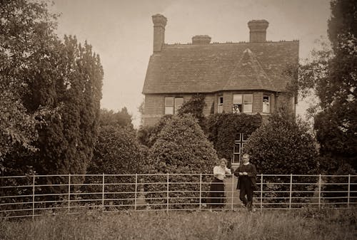 Country House And Garden with Man and Woman Standing Near a Fence