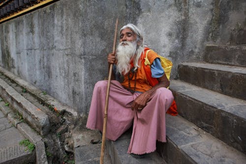 Elderly Monk Sitting on Stairs 