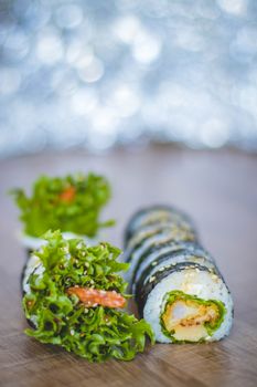 这款铺有海藻和生菜的木质表面寿司卷，非常适合烹饪主题
