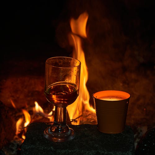 A glass of wine at the campfire at night