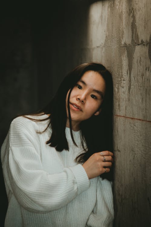アジアの女性, コンクリートの壁, セーターの無料の写真素材