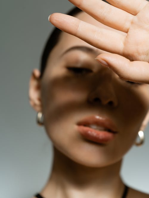 Close Up Photo of Hand near Woman's Face