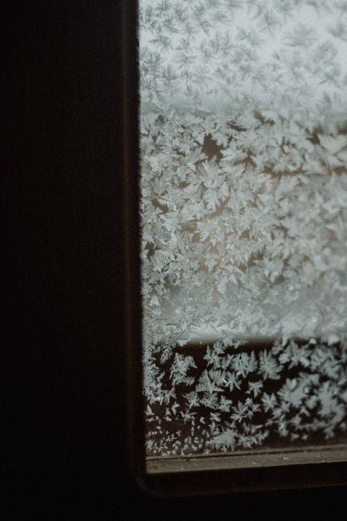 Free Detailed imagery of snowflakes forming intricate patterns on a frosty window during winter. Stock Photo