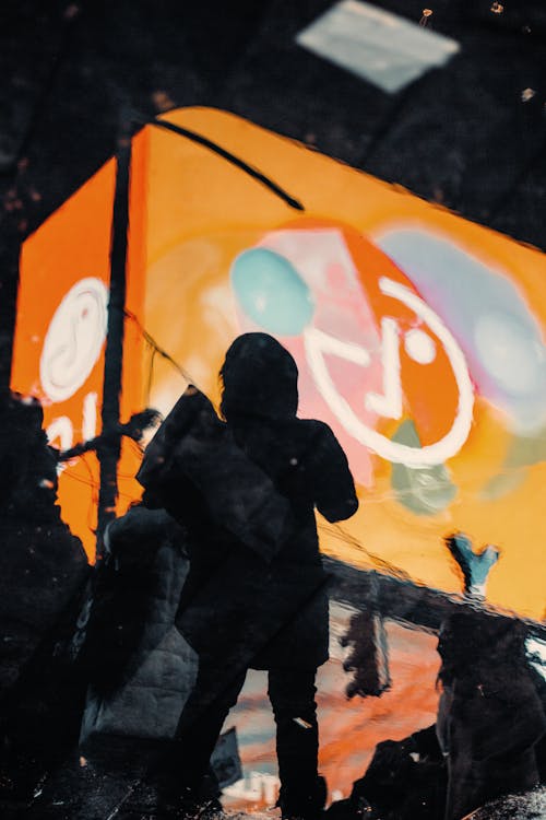 Silhouettes of People against a Billboard 