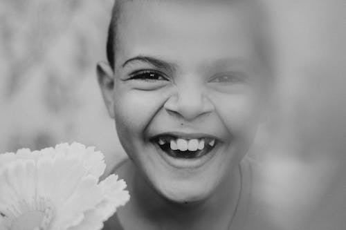 Grayscale Photo of a Kid Smiling