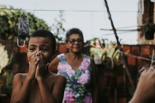 Photo of a Boy Covering His Mouth