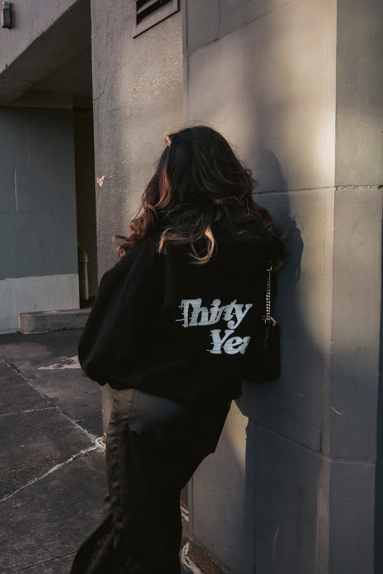 Back Of A Woman Leaning On A Wall