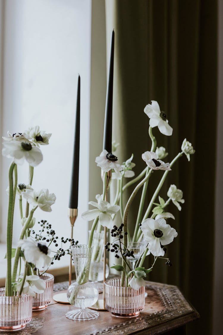 White Cut Flowers And Black Slim Candles Standing On Ornate Table