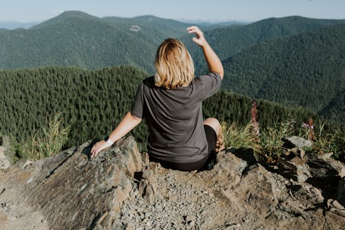 Woman in Gray T-shirt Sitting on Mountain Top