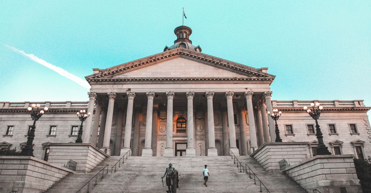 Striking view of the South Carolina State House with its grand steps and clear blue sky backdrop.