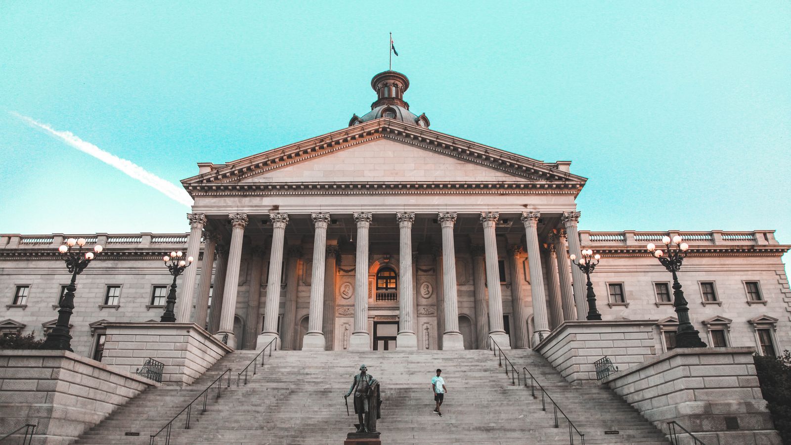 Striking view of the South Carolina State House with its grand steps and clear blue sky backdrop.
