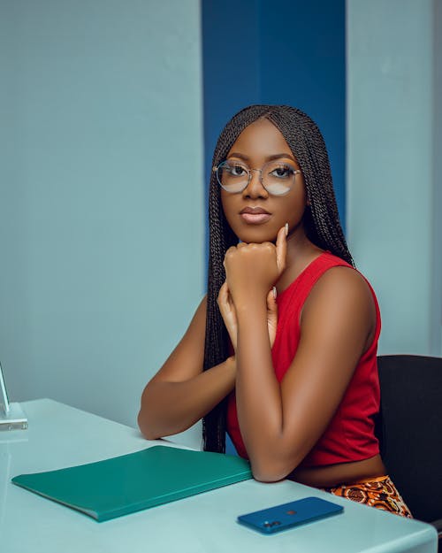 Woman in Red tank Top Leaning on a Desk