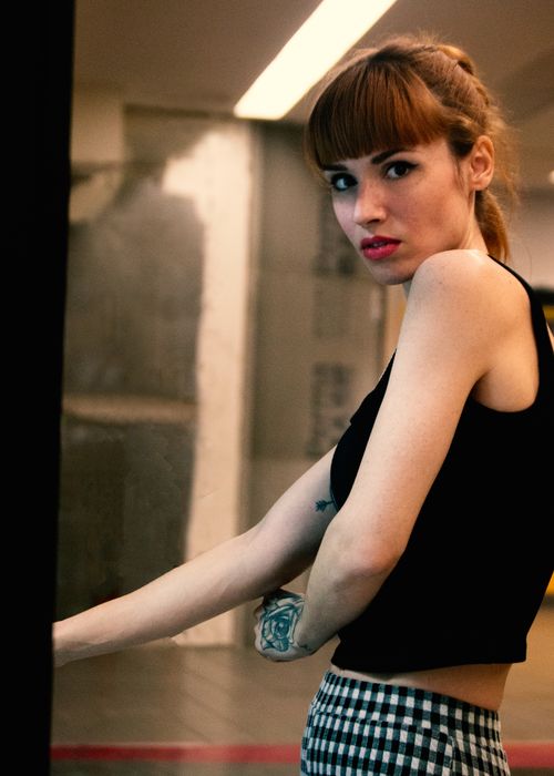 Free Portrait of a woman with tattoos and red lips in a modern indoor environment. Stock Photo