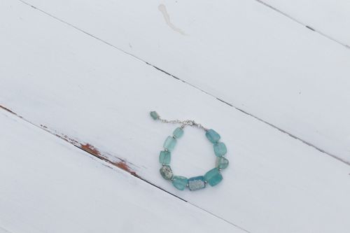 Free Close-up of an aquamarine bracelet on wooden background, showcasing simplicity and elegance. Stock Photo