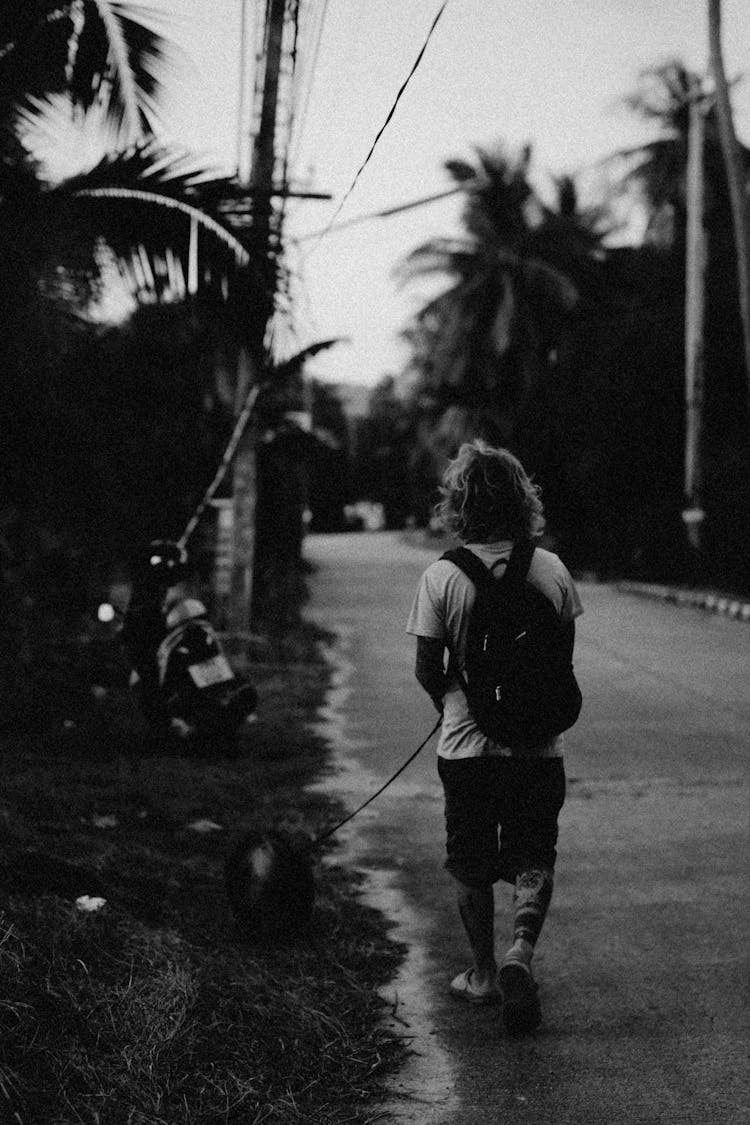 Man Walking On Street With A Dog