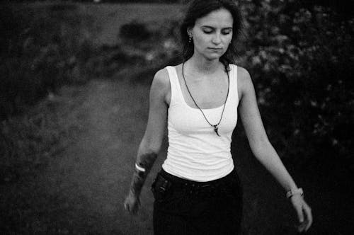 Monochrome Photo of a Woman with a Necklace Walking