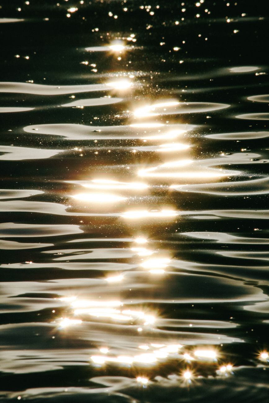 Captivating sunlight reflections create a shimmering pattern on a tranquil water surface.