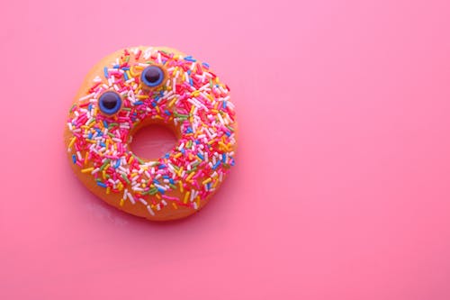 Безкоштовне стокове фото на тему «їжа, пончик, рожевий фон»