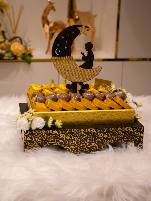 Free Luxurious chocolate gift box with Ramadan theme, featuring crescent moon and star decorations. Stock Photo