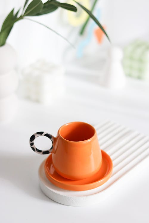 Orange Cup and Saucer Standing on White Design Tray