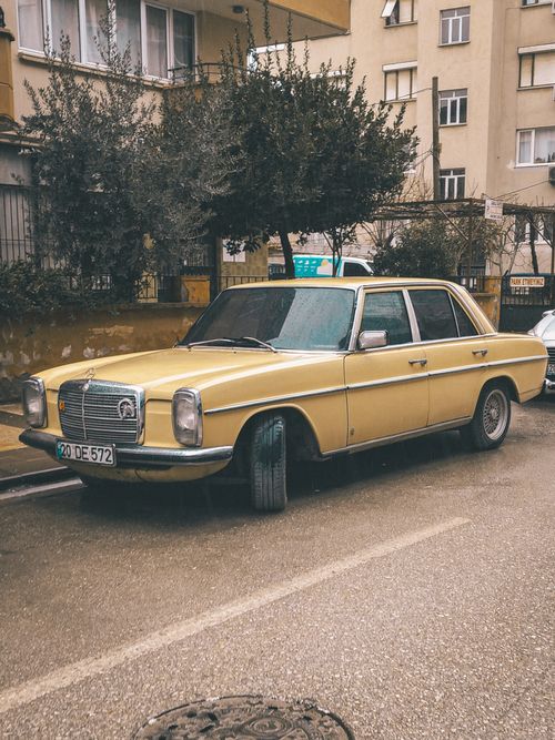 Free Old yellow car parked on the street in Denizli, Turkey, capturing a nostalgic urban vibe. Stock Photo