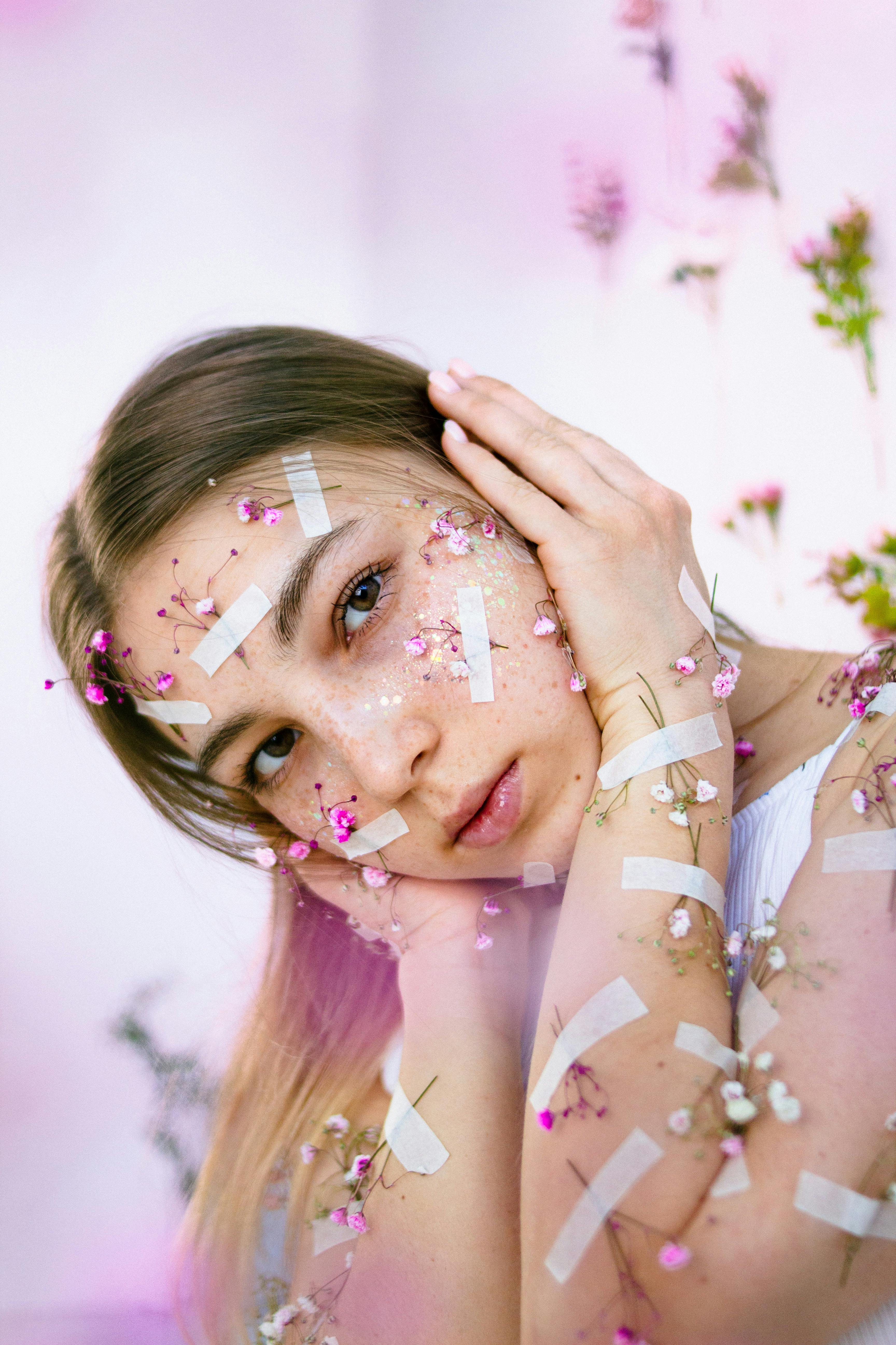 teenage girl with tiny flowers attached to her face and hands