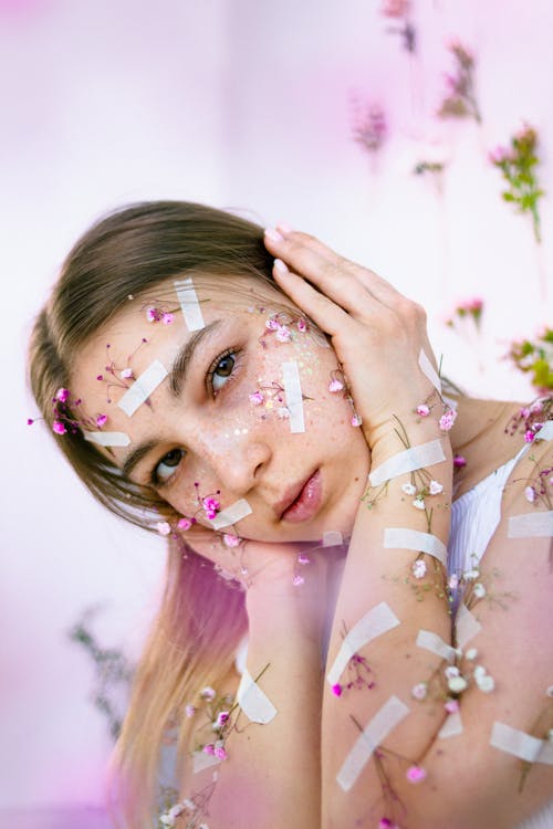 Teenage Girl with Tiny Flowers Attached to Her Face and Hands